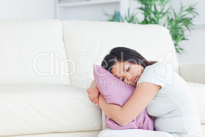 Woman sleeping while holding a pillow