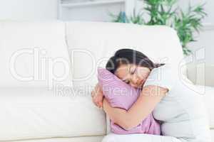 Woman sleeping while holding a pillow