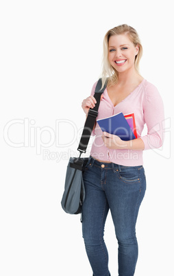 Happy blonde woman holding notebooks