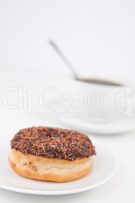 Chocolate doughnut and a cup of coffee on white plates
