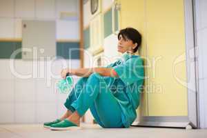 Thinking surgeon sitting on the floor