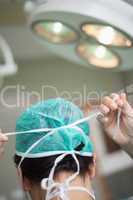 Woman surgeon putting a surgical hat on