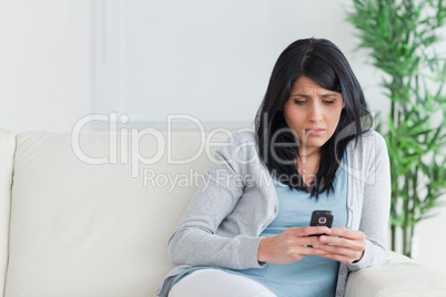 Woman looking at a phone on a couch