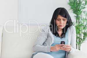 Woman looking at a phone on a couch