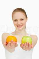 Close up of a young woman presenting fruits