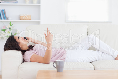 Woman relaxing on a sofa while phoning