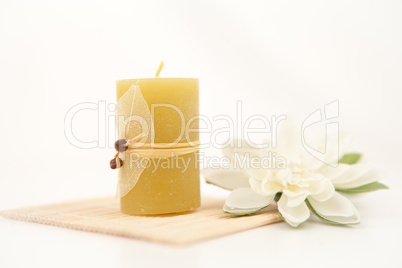 Yellow candle with a white flower