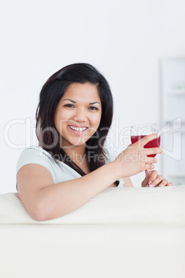 Smiling woman holding a glass of red wine