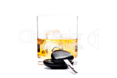 Car key in front of a glass of whiskey