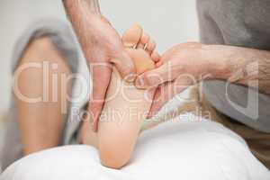Chiropodist touching the foot of a woman