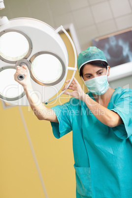 Woman surgeon holding a surgical light