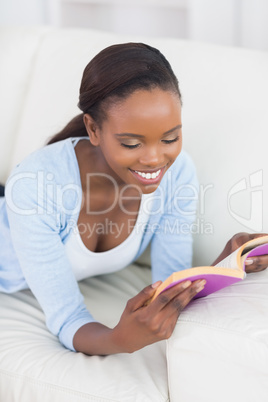 Black woman lying on front on a sofa