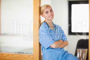Smiling nurse sitting with arms crossed