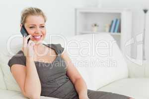 Woman calling while she is sitting on a sofa
