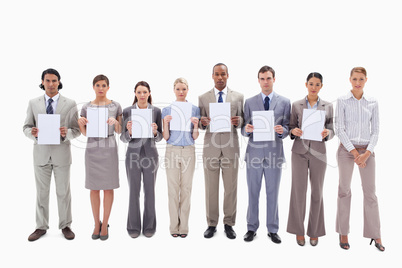 Business people holding seven supports for letters