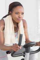 Concentrated black woman doing exercise bike