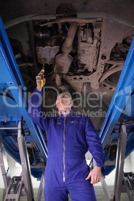 Mechanic repairing a car with an adjustable pliers