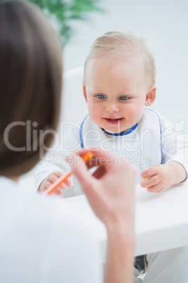 Baby looking at a plastic spoon