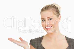 Smiling woman presenting something with her hand