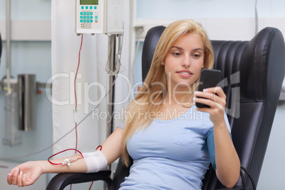 Blood donor looking at her mobile phone