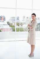 Businesswoman standing upright in front of the bright window