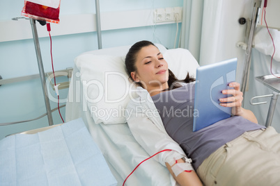 Female transfused holding a tablet computer