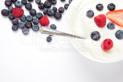 Bowl of cream with berries and a spoon