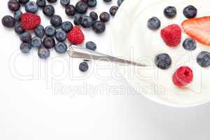 Bowl of cream with berries and a spoon