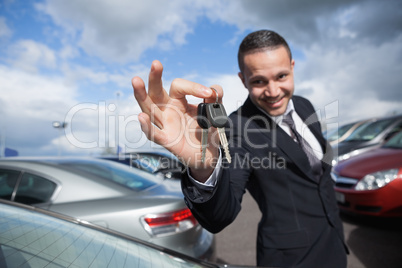 Happy dealer holding car keys