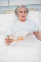 Patient reading a magazine on her bed