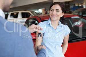 Woman smiles as she shakes someone hand