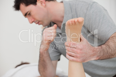 Physio manipulating the leg of a patient