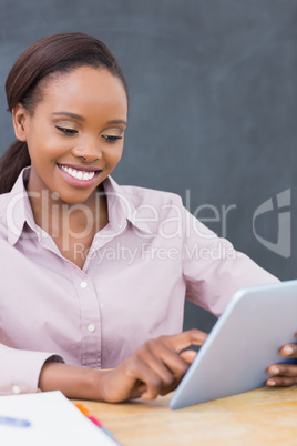 Teacher smiling while using a tablet computer
