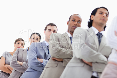Low-angle shot of people dressed in suits crossing their arms in