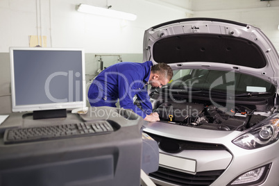 Mechanic examining an engine of a car