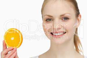 Smiling woman presenting an orange slice