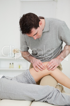 Physiotherapist pressing on the knee of a patient