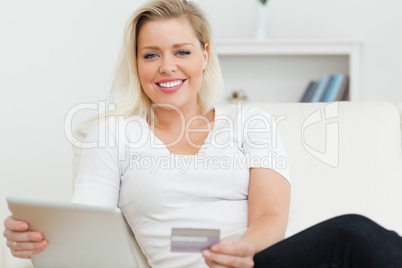 Casual woman with tablet pc and a credit card