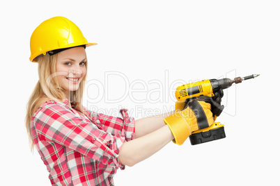Smiling woman using an electric screwdriver