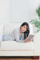 Woman holding a book while relaxing on a couch