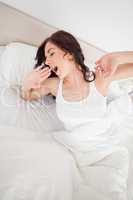 Brunette woman yawning while waking up