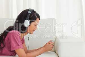 Young Latino listening music with her smartphone