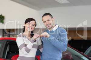 Smiling couple standing next to a car