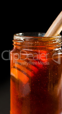 Close up of a honey jar with a honey dipper