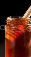 Close up of a honey jar with a honey dipper