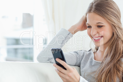 A smiling girl looking at her mobile phone