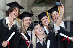Close-up of happy graduates taking a picture of themselves