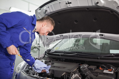 Mechanic looking at a dipstick while holding it