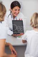 Doctor holding a tablet computer in front of a child