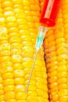Syringe with red liquid on corn